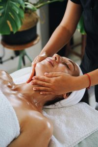 A woman enjoys a calming face massage at a spa, promoting relaxation and wellness.